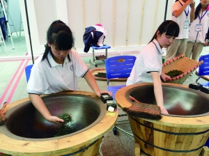 小姑娘肖曼（左）和同学正在炒茶 活动方供图