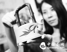 7月17日，一名来自江苏宜兴的紫砂艺术家正在展示自己的紫砂壶作品。当日，2015山西茶叶博览会在中国（太原）煤炭交易中心开幕，吸引了来自全国各地600多家品牌茶企参展，部分非物质文化遗产项目也在展会展示。本报记者阮洋摄